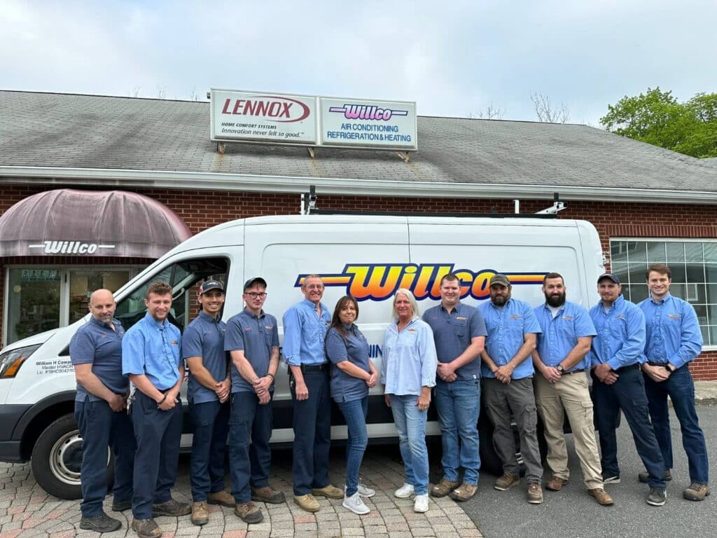 Willco Air Conditioning, Refrigeration & Heating team members standing in front of a Willco service van, below the company's Lennox and Willco signs